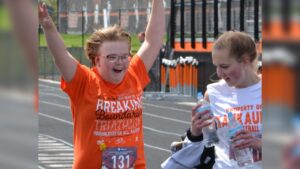 A runner crosses the finish line during the KHS adaptive triathlon.