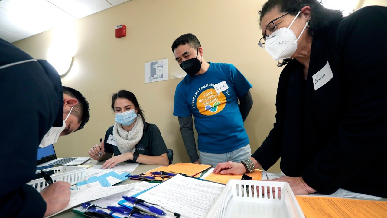 Long Vue, center, collaborates with Claire Holzschuh, left, a public health educator with the Menasha Health Department, and Susana Guerra, right, a volunteer with Casa Hispana, to assist residents registering at a free COVID-19 vaccine clinic in Menasha, Wis. Vue moved to northeastern Wisconsin in 1980. He says the racism he faced back then resurfaced after former President Donald Trump began using the term “China virus” to describe the virus that causes COVID-19. Dan Powers / USA TODAY NETWORK-Wisconsin