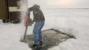 A fisherman prepares to open the ice for the annual sturgeon spearfishing season on Lake Winnebago in this file photo from the Wisconsin DNR
