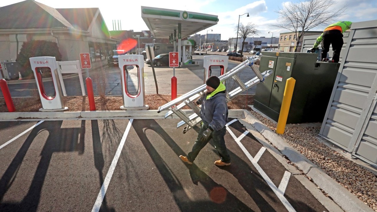 Workers with Delta Metal Work work to enclose the electrical components of a charging station for electric vehicles along East Washington Avenue in Madison, Wis., on Dec. 8, 2021. A bill to make it easier to install electric vehicle charging stations is being debated in the Legislature, but amendments to the bill have turned some clean-energy groups against it. John Hart / Wisconsin State Journal
