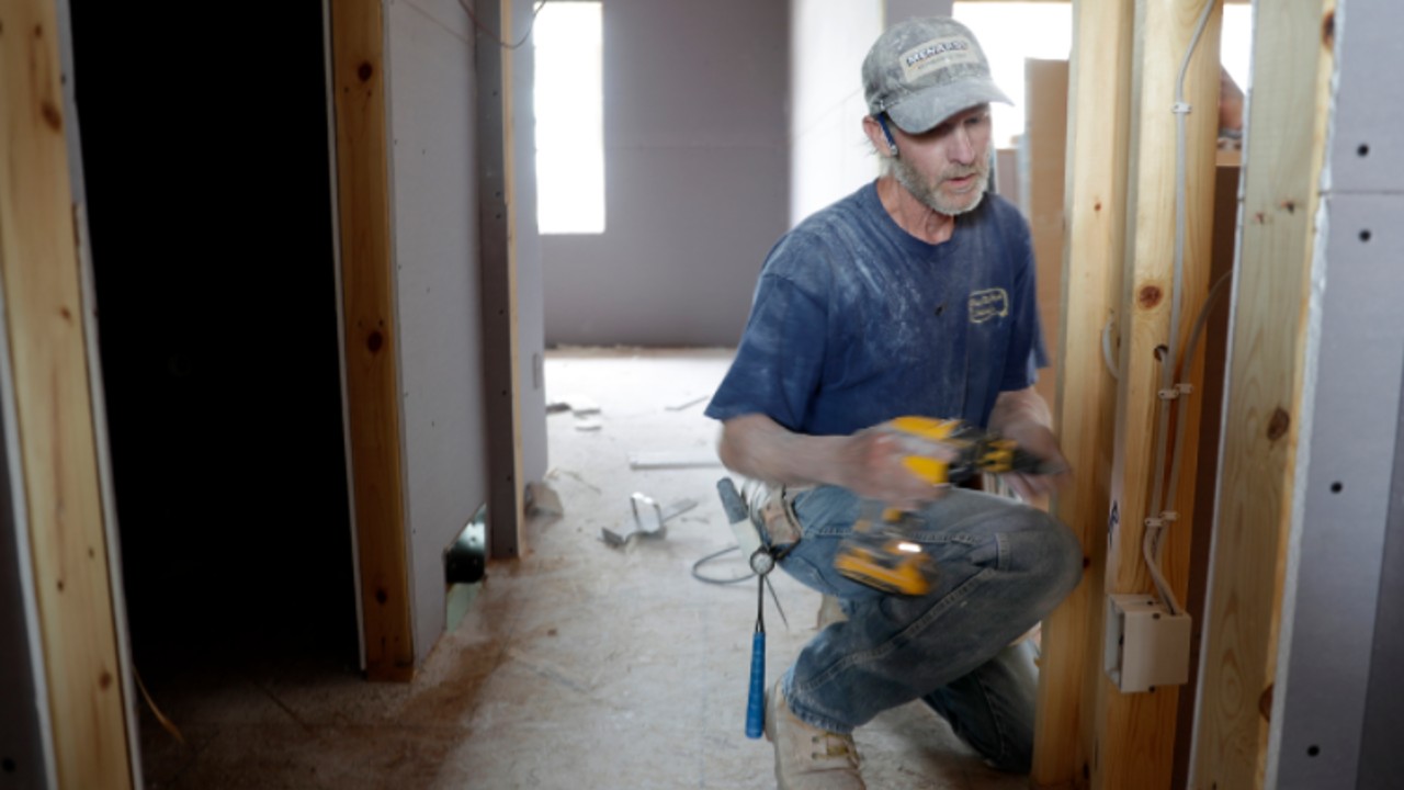 John Fischer of Hang Em High Drywall works in a home being built by Tom McHugh Construction near Haas Road in Kaukauna, Wis. (Wm. Glasheen/Appleton Post-Crescent)