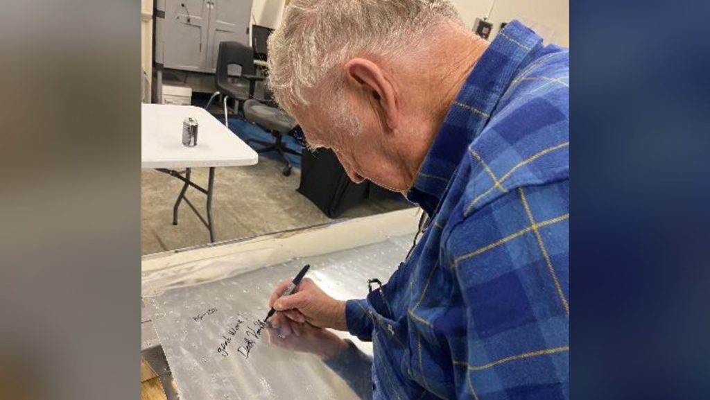 Dick Van Grunsven, designer and creator of Van’s Aircraft, inspecting and signing the teens’ work. Van Grunsven, from Oregon, was in Oshkosh at EAA HQ and stopped by the chapter 252 hangar to check out the project.
